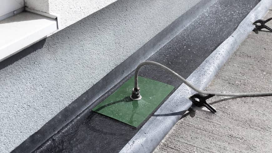 Arbeiter reinigt eine betroffene Fassade mit Hochdruckreiniger